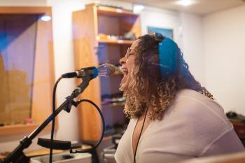 Jernie singing into microphone in studio