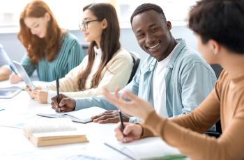 People talk as they work in a meeting room.