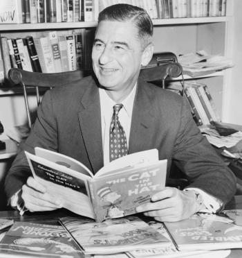 A black and white photo of Dr. Seuss reading "The Cat in the Cat."