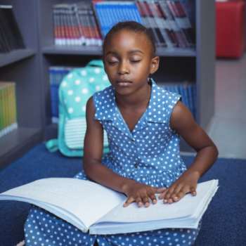 Photograph of child reading braille