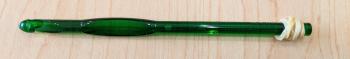 A photo of a green k-10.5 crochet hook with a rubber band wrapped around the end of the hook