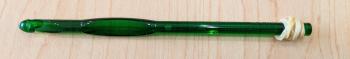 A photo of a green k-10.5 crochet hook with a rubber band wrapped around the end of the hook