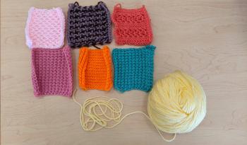 A photo of six Tunisian crochet swatches laid out next to each other, with a skein of yellow yarn next to them.