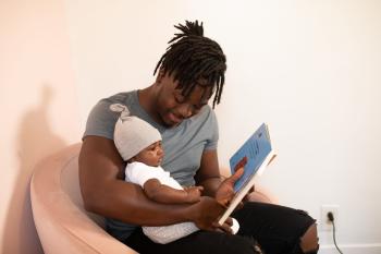 father reading aloud to baby - cropped