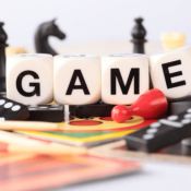 board game pieces with dice spelling "game"