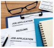 Job applications and resume with a notebook and glasses on a desk