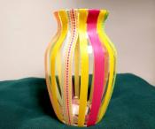 vase decorated with washi tape in green, orange, yellow and pink vertical stripes