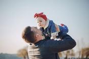 man lifting baby in air