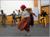 An African American woman dancing in colorful African clothes